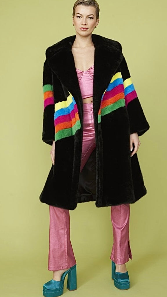 front view of model wearing a long black fur coat with multicolor stripes,.