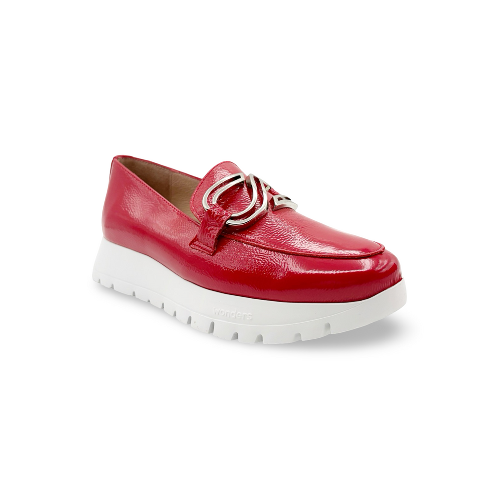 Red loafer shoe with a white platform sole and silver buckle detail 
