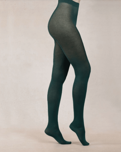 Dark green tights worn by a person on a beige background
