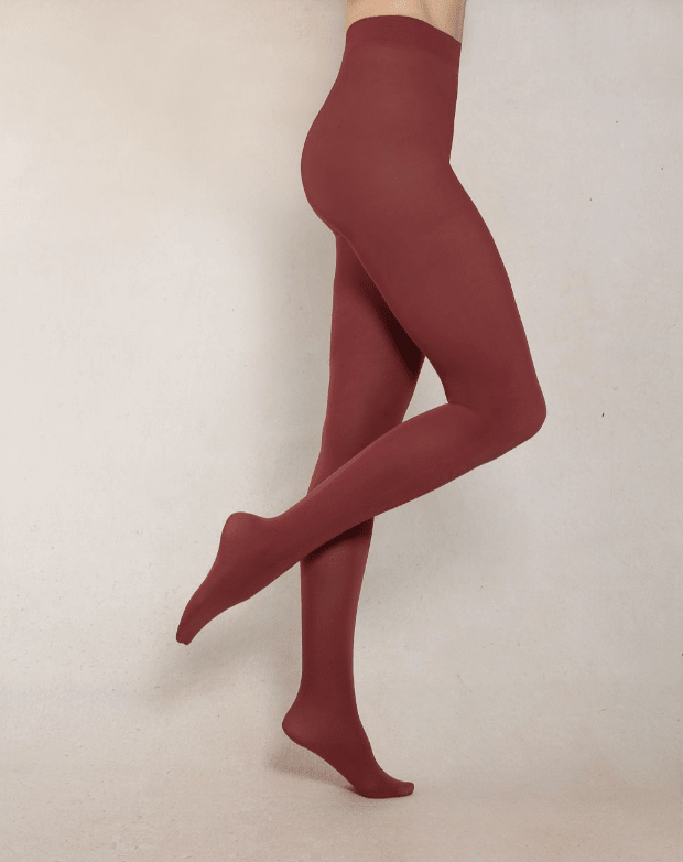 Maroon tights worn by a person on a beige background